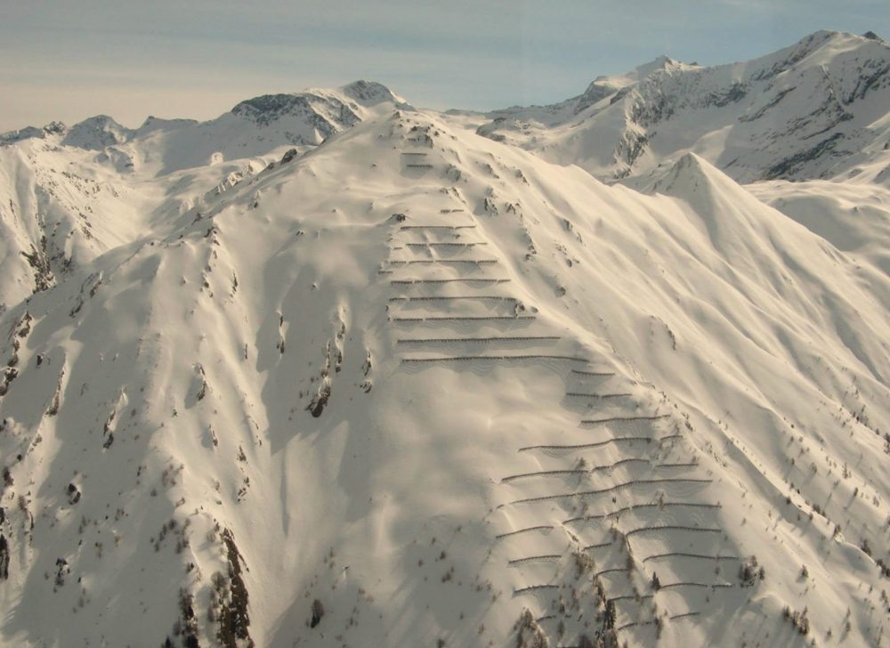 Rows of avalanche fences across an alpine slope